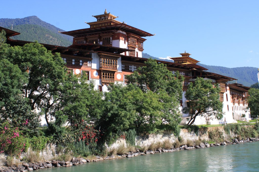Punakha Dzong along a river with lush greenery in Bhutan.